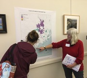 Two people viewing a poster